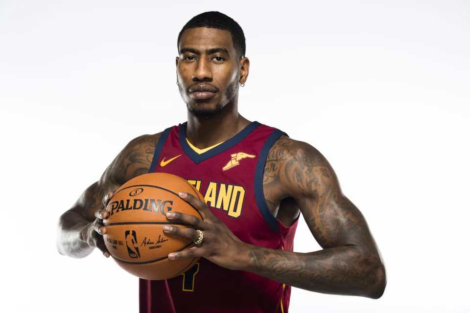 Amerikanischer Basketballspieler mit einem Ball in den Händen vor weißem Hintergrund