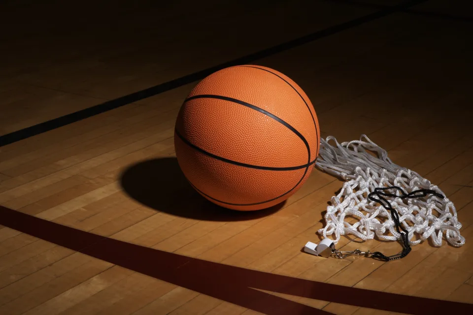 Basketball, Pfeife und Netz auf dem Hallenboden