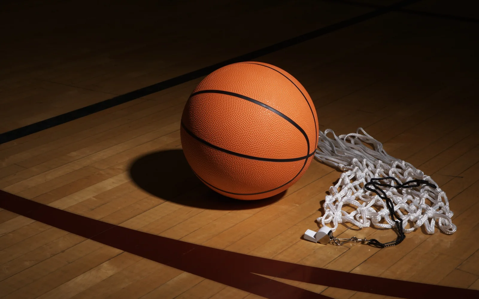 Basketball, Pfeife und Netz auf dem Hallenboden