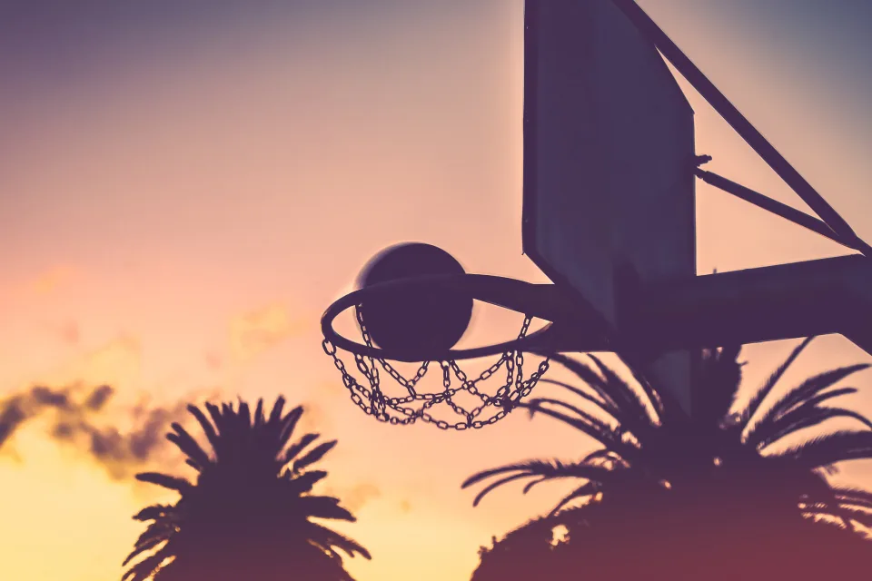 Basketballkorb mit einem Ball bei Sonnenuntergang