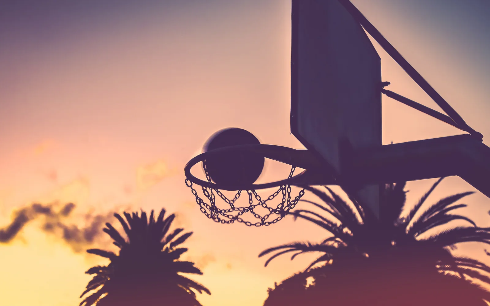 Basketballkorb mit einem Ball bei Sonnenuntergang