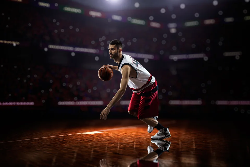 Basketballspieler mit einem Ball spielt auf dem Feld