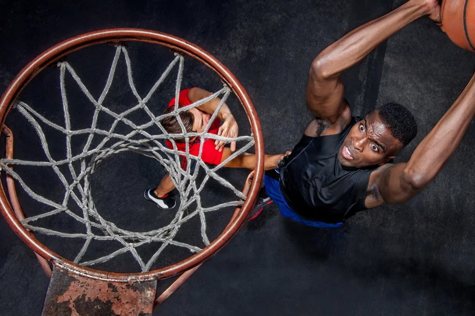 Basketballspieler wirft Ball in Korb