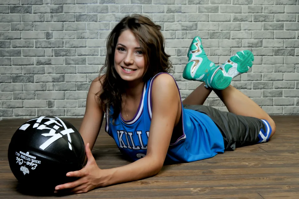 Lächelnde Frau Basketballspielerin mit einem Ball