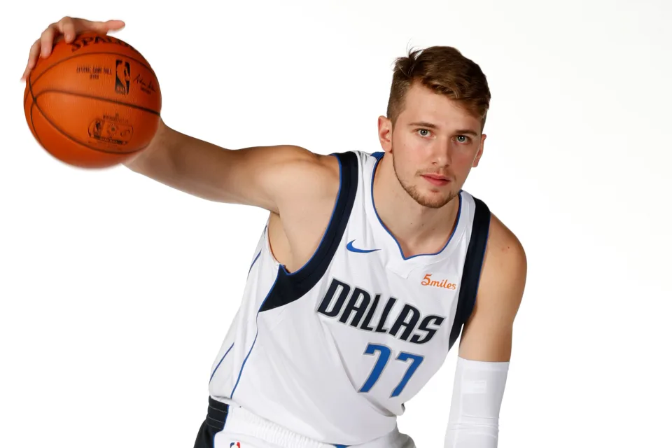 Slowenischer Basketballspieler Luka Dončić vor weißem Hintergrund mit einem Ball