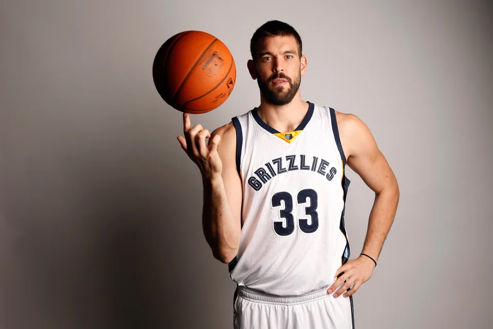 Spanischer Basketballspieler mit einem Ball vor grauem Hintergrund