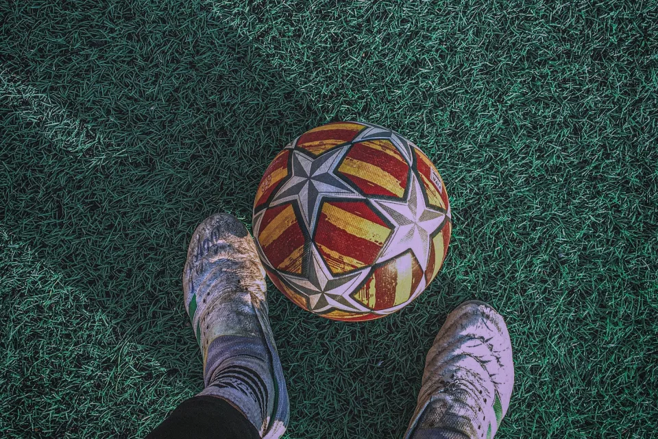 Fußball auf grünem Feld mit Fußballspieler