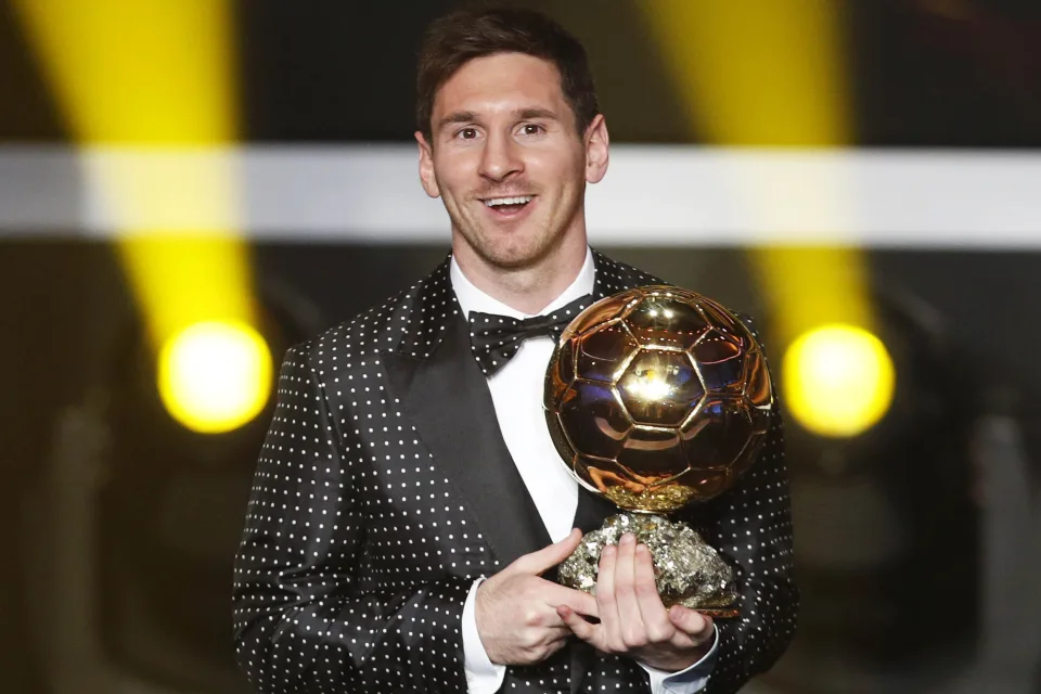 Fußballspieler Lionel Messi mit dem Goldenen Ball in den Händen