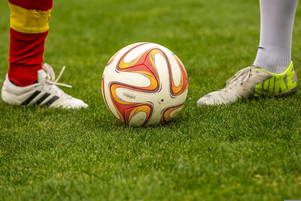 Fußballspieler mit einem Ball auf grünem Gras
