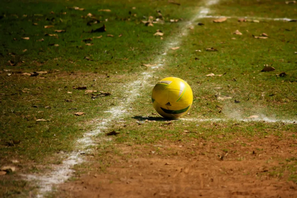 Gelber Ball auf dem Fußballplatz im Herbst