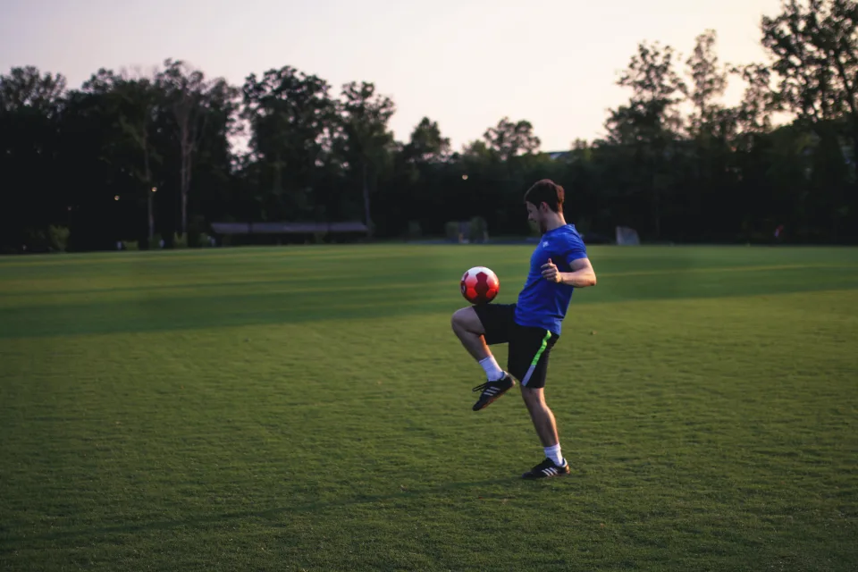 Mann Fußballspieler mit einem Ball auf dem Feld
