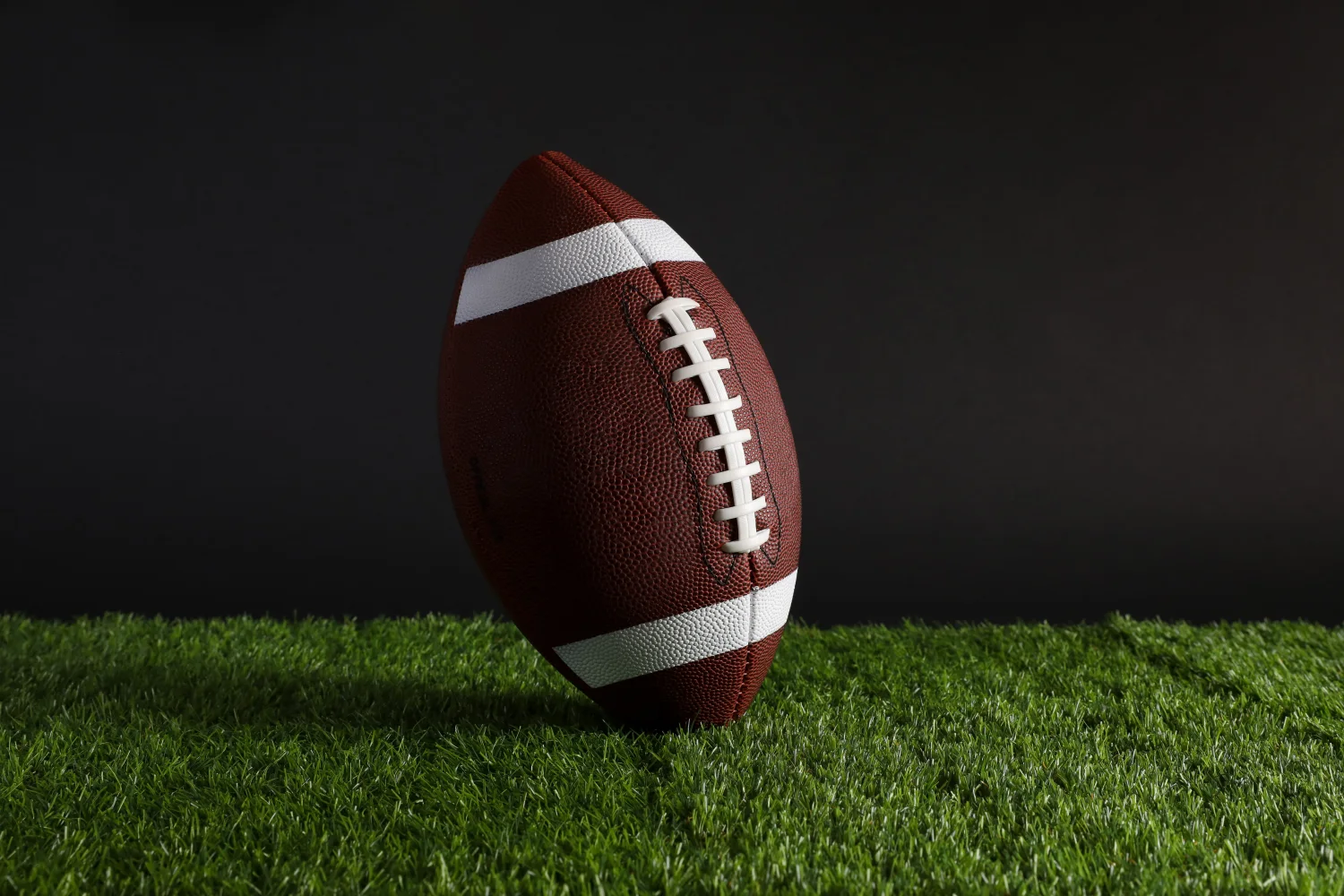 Neuer Leder Ball für amerikanischen Fußball im Gras