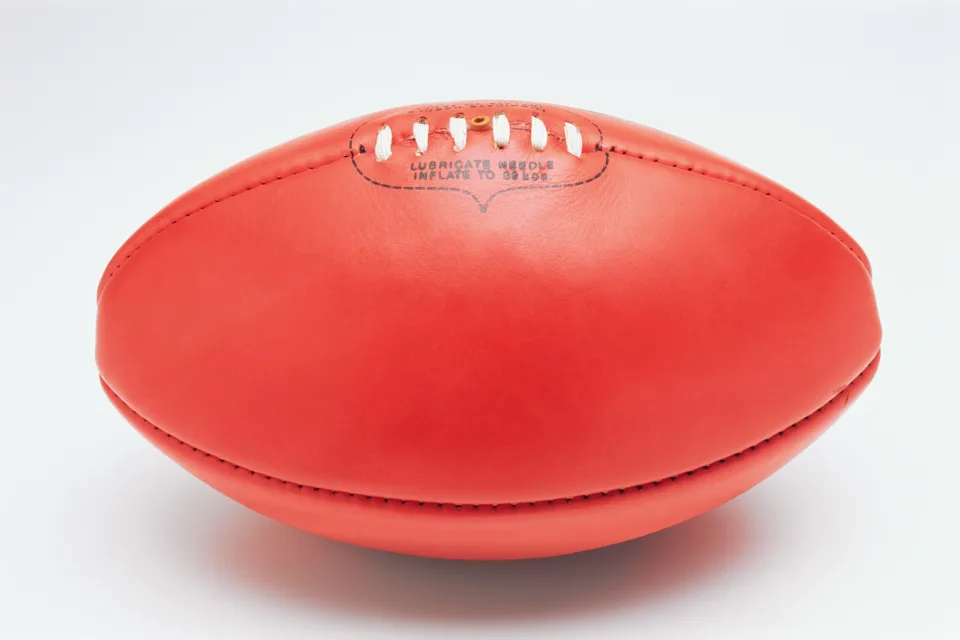 Roter Ball für amerikanischen Fußball vor weißem Hintergrund