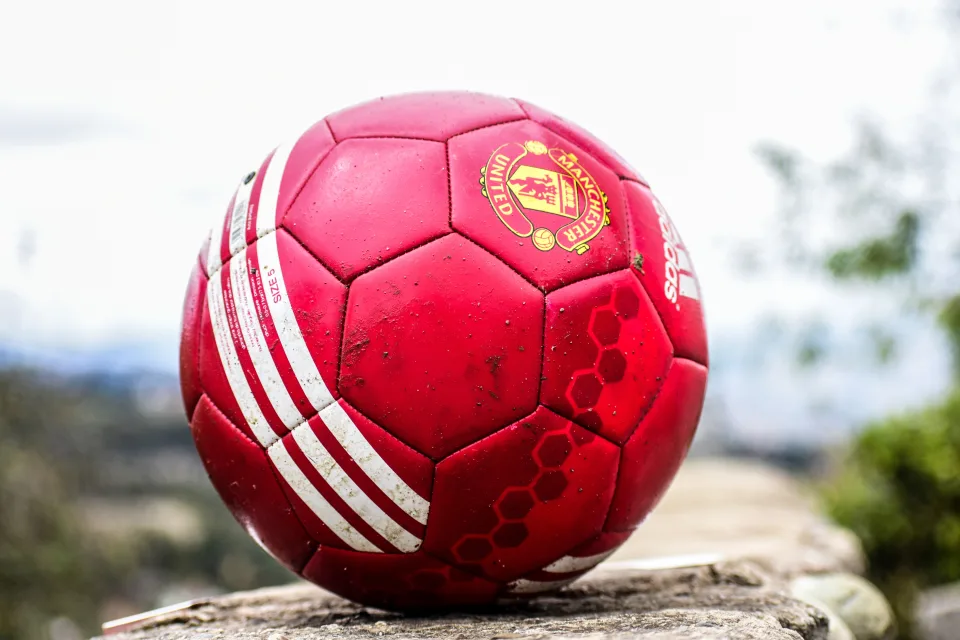 Roter Fußball liegt auf einem Stein