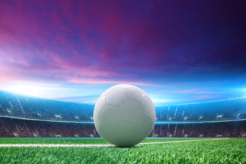 Weißer Fußball auf grünem Gras im Stadion