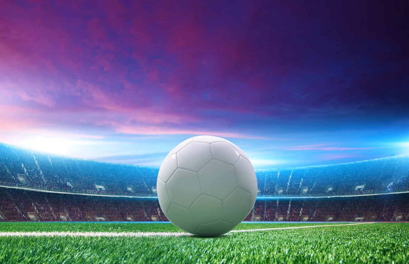 Weißer Fußball auf grünem Gras im Stadion