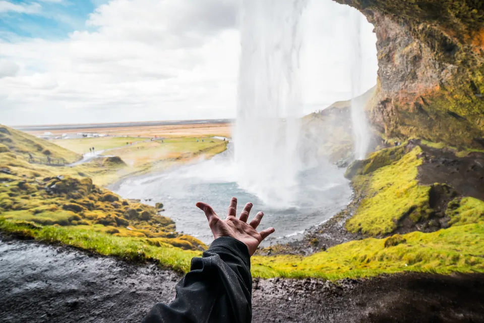 Hand zu Wasserfall Seljalandsfoss, Island