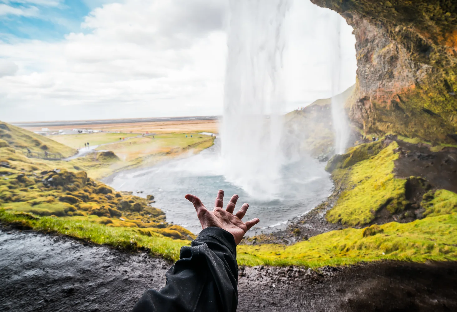 Hand zu Wasserfall Seljalandsfoss, Island
