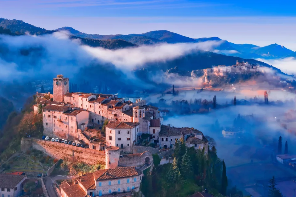 Blick auf Stadt auf dem Berg im Nebel, Italien