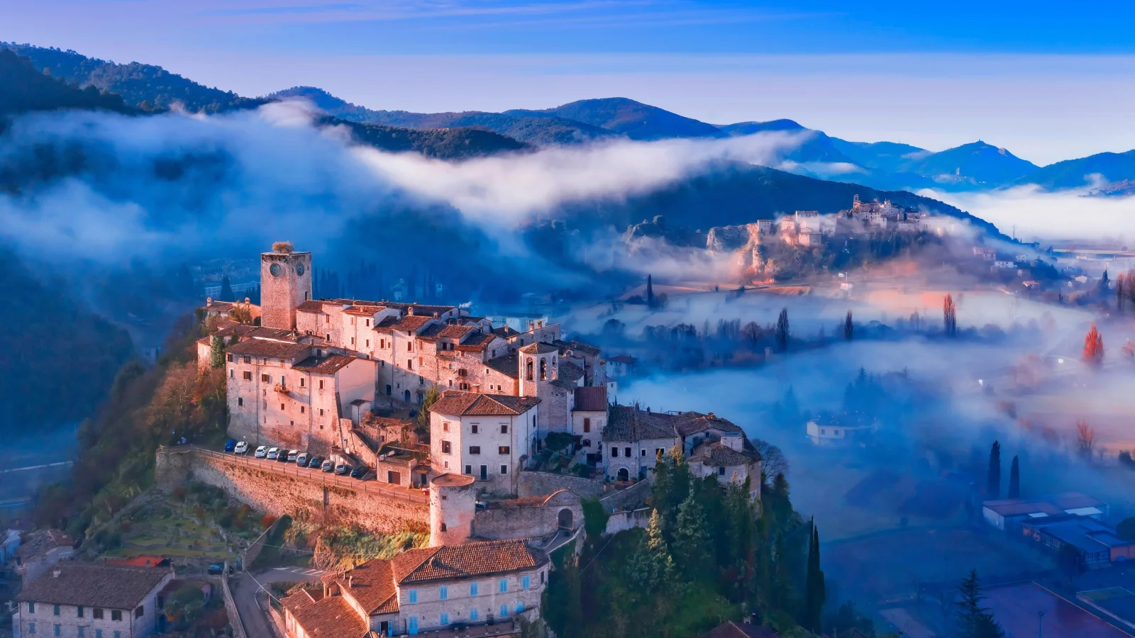 Blick auf Stadt auf dem Berg im Nebel, Italien
