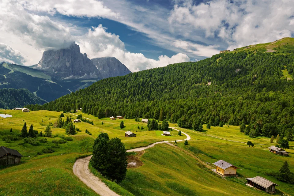 Blick auf Wald und Alpen unter weißen Wolken, Italien