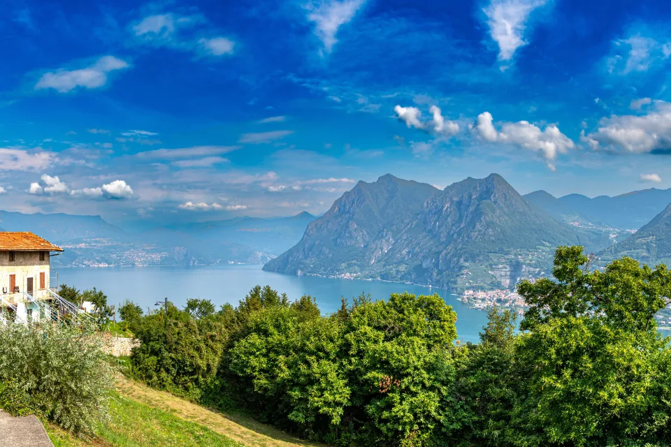 Schöner Blick auf See und Berge unter hellblauem Himmel, Italien