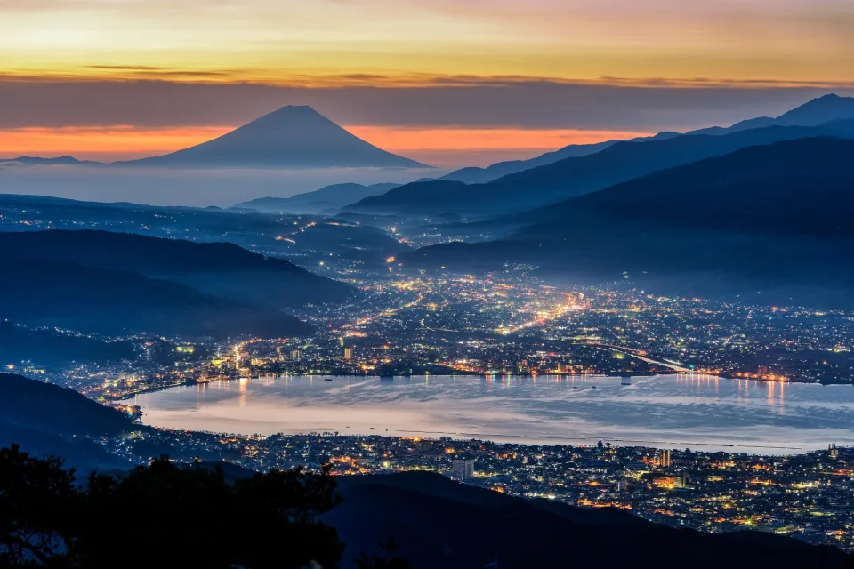 Nacht Stadt vor einer Bergkulisse Fuji, Japan