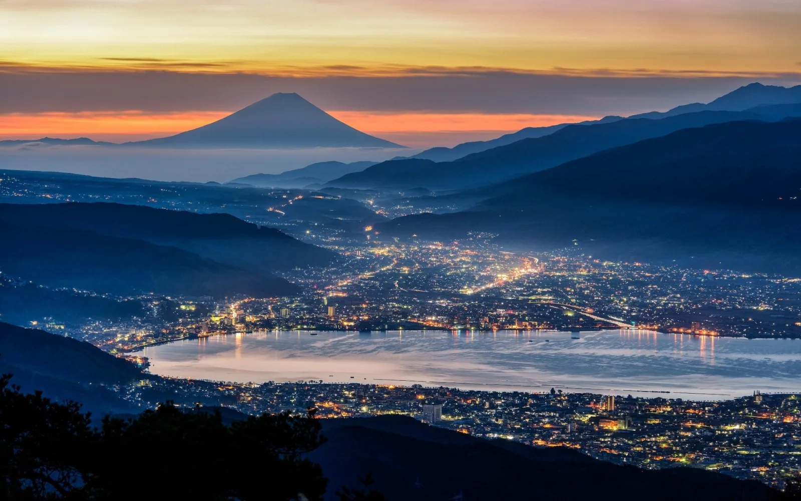 Nacht Stadt vor einer Bergkulisse Fuji, Japan