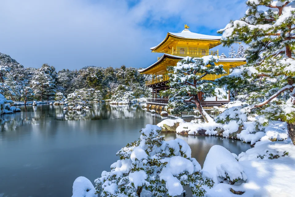 Schneebedeckte Baum und vereister Teich bei Tempel im Winter, Japan