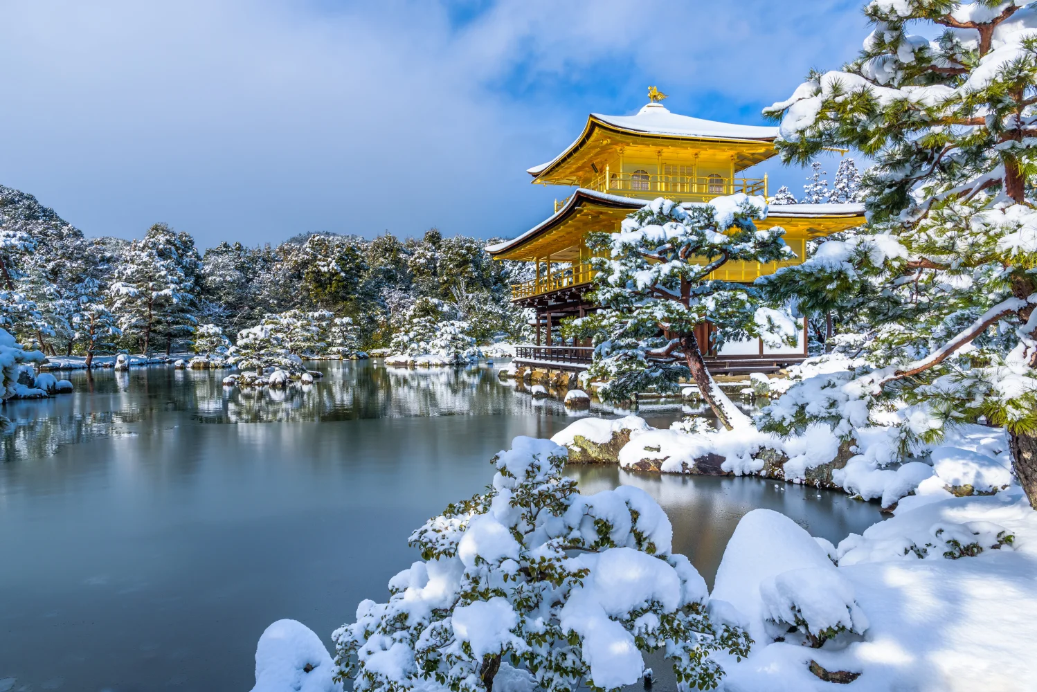 Schneebedeckte Baum und vereister Teich bei Tempel im Winter, Japan