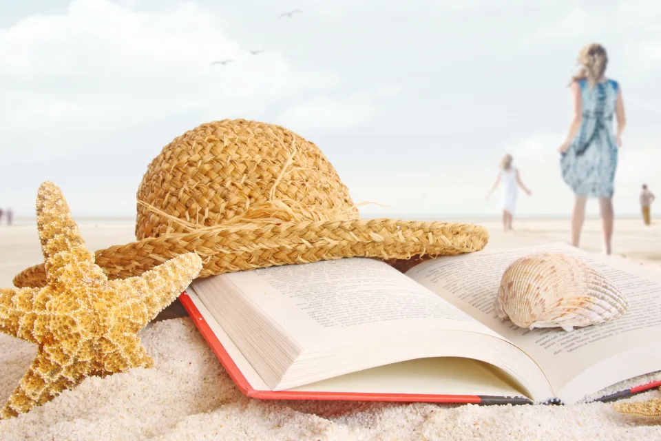 Buch, Muscheln, Meeres Sterne und Hut im Sand im Sommer
