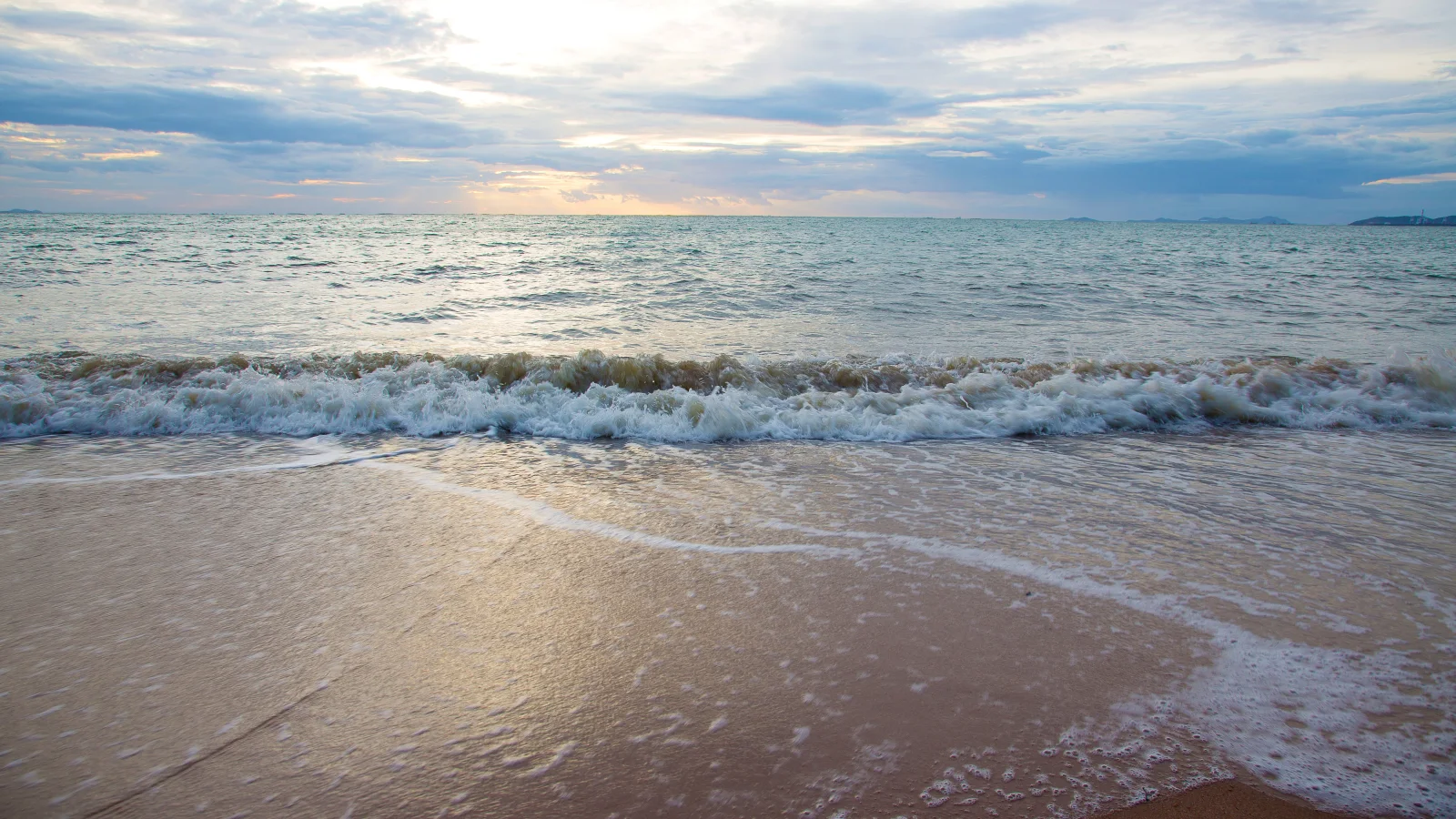 Wellen auf heißem Sand im Sommer