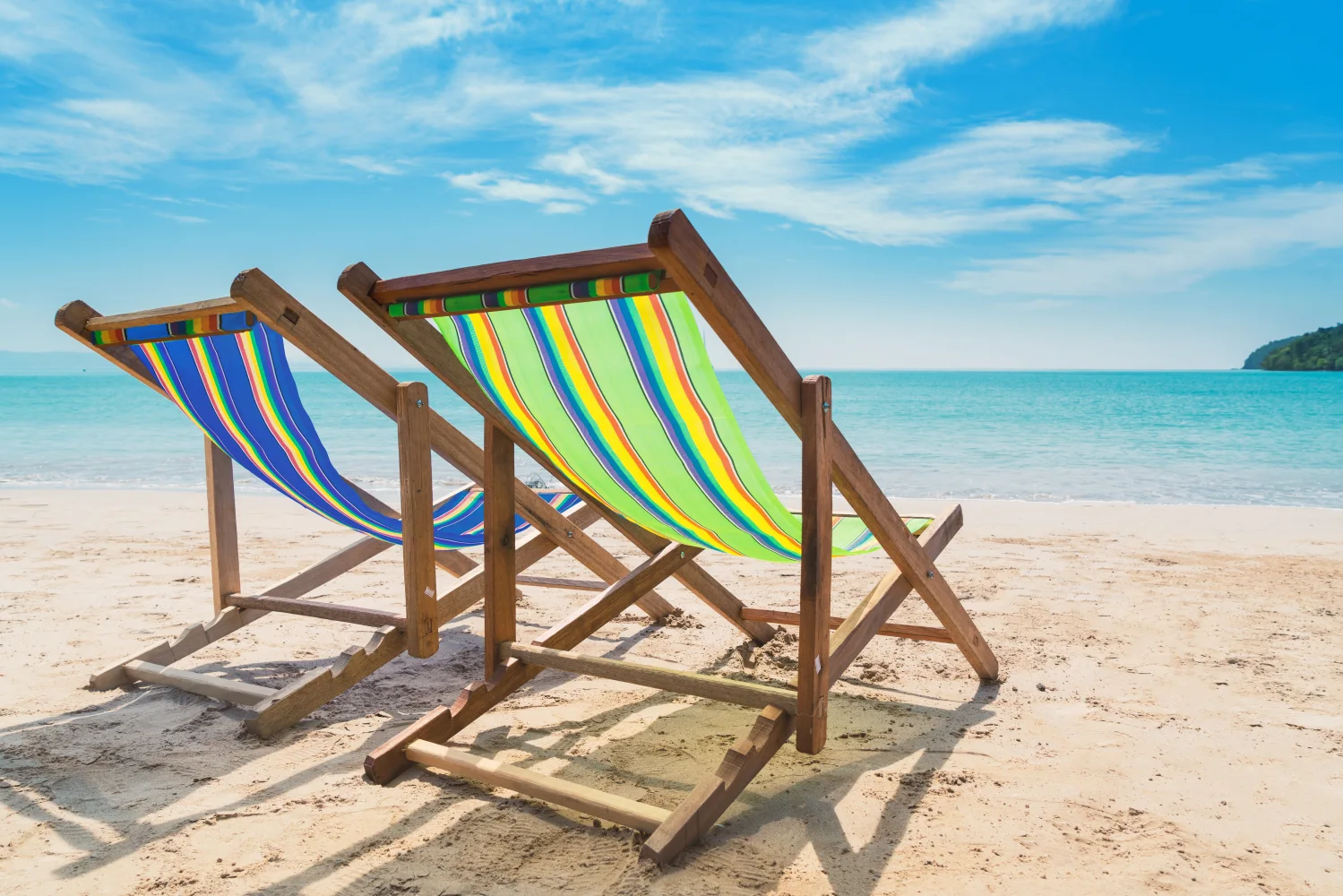 Zwei Liegestuhls stehen im Sand am Strand im Sommer