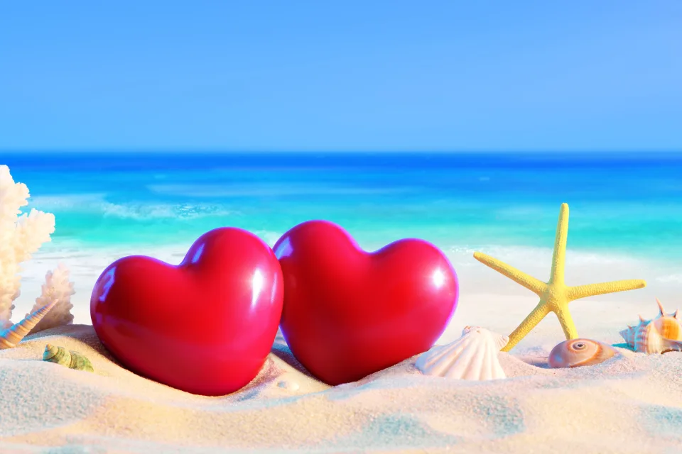 Zwei roten Herzen am Strand mit Meeres Sterne im Sommer