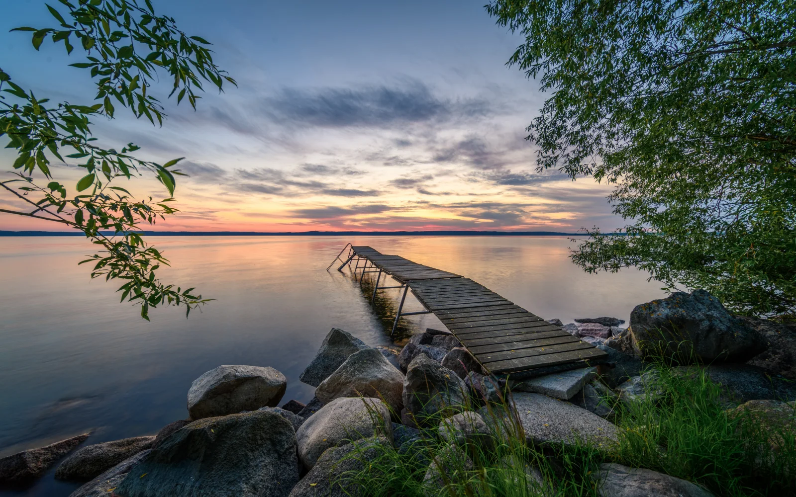 Alter hölzerner Steg am See bei Sonnenuntergang