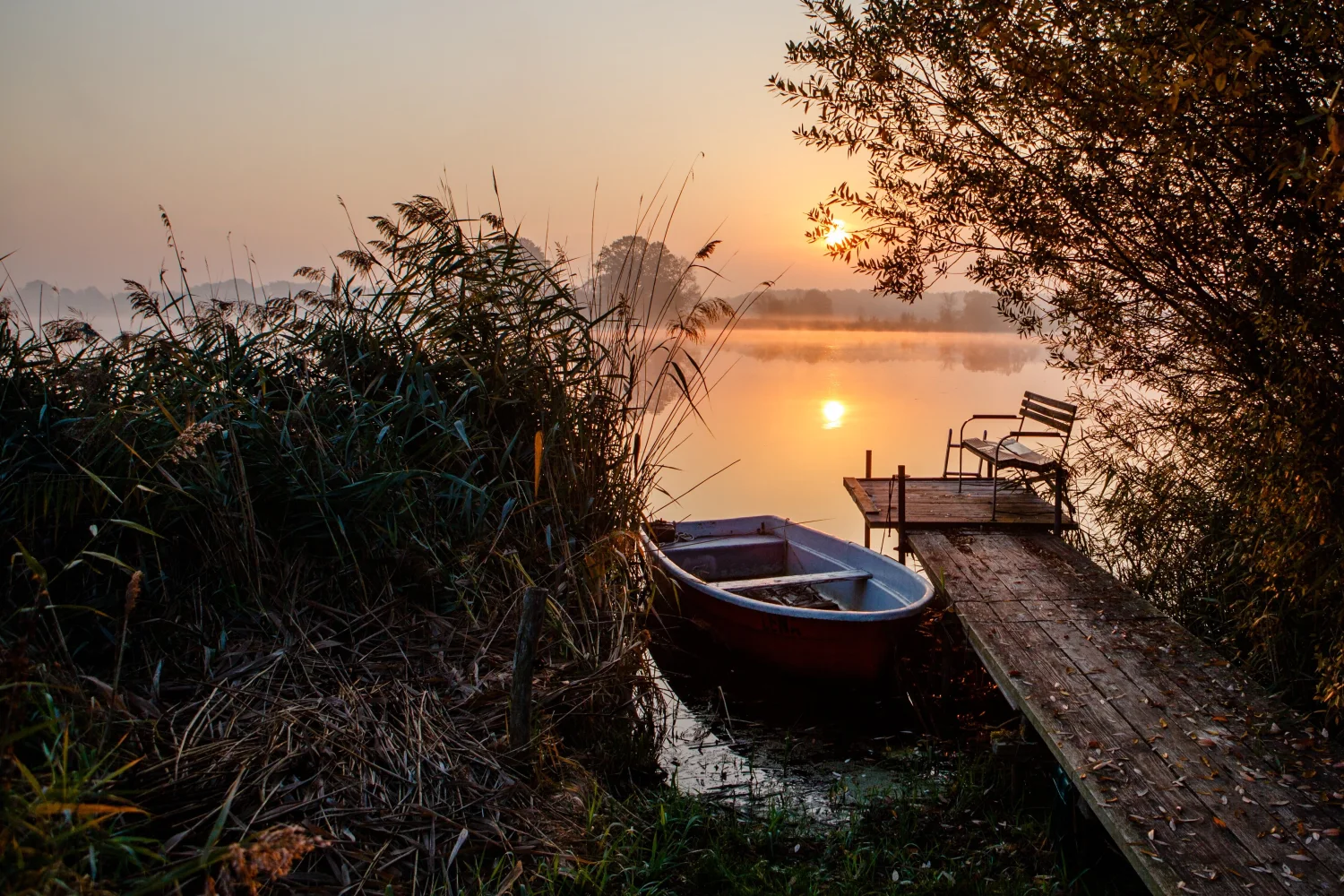 Boot am Seeufer bei Sonnenuntergang