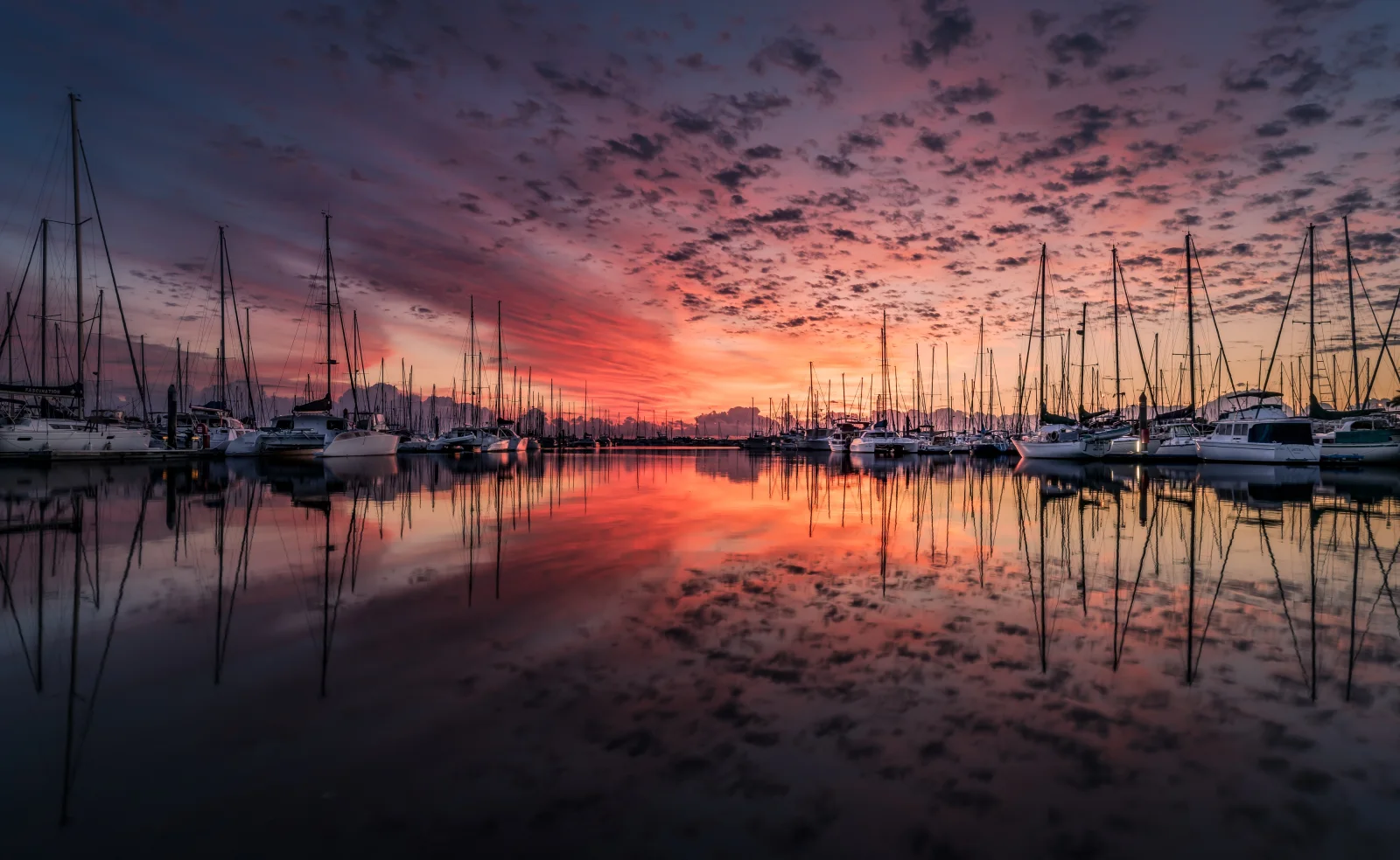 Boote bei Bootssteg im Wasser bei Sonnenuntergang