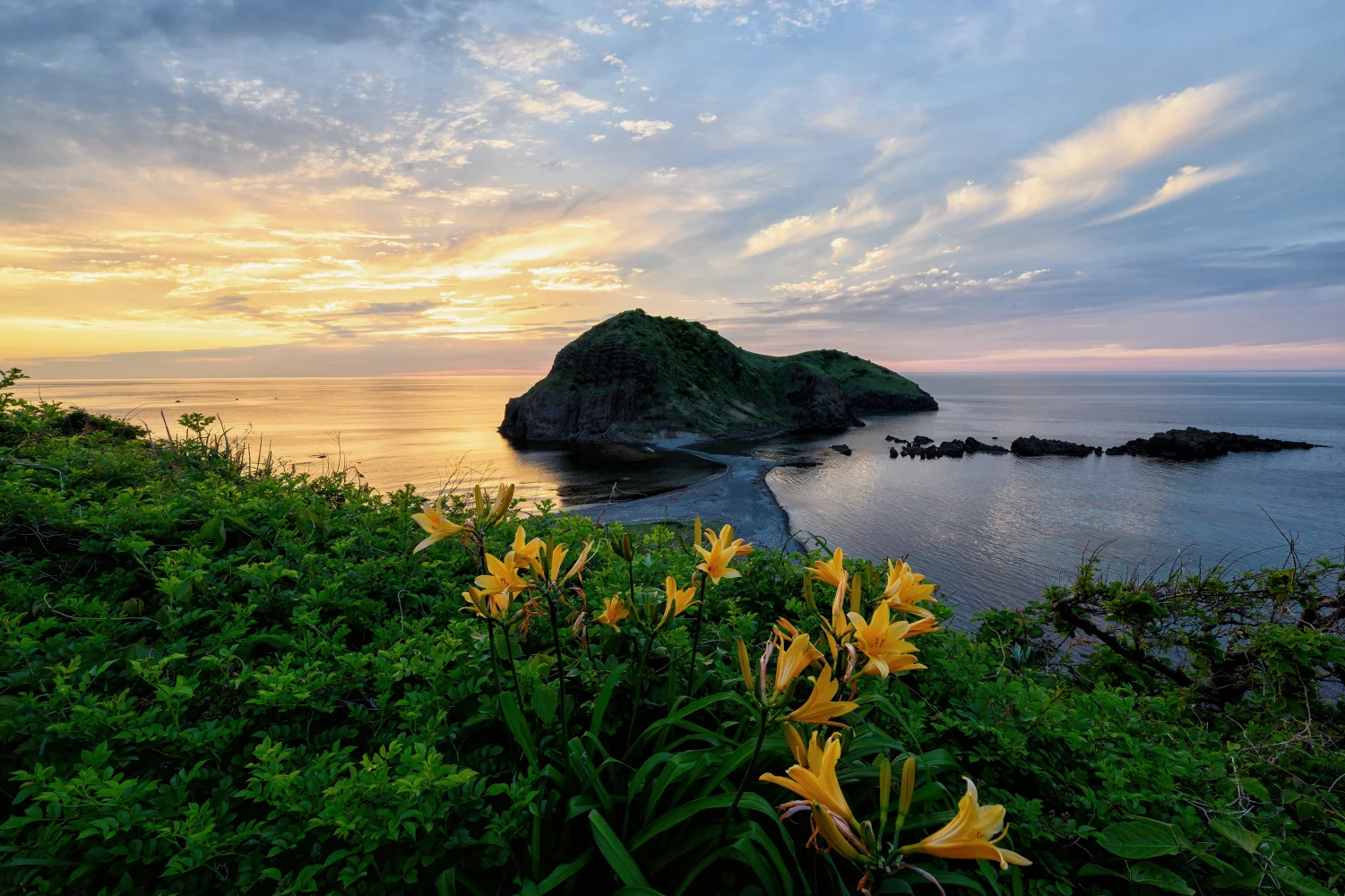 Grüne Insel im Ozean bei Sonnenuntergang