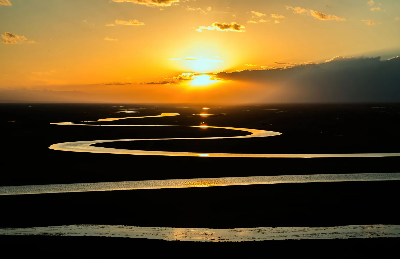 Kurvenreiche Fluss im Sonnenlicht bei Sonnenuntergang