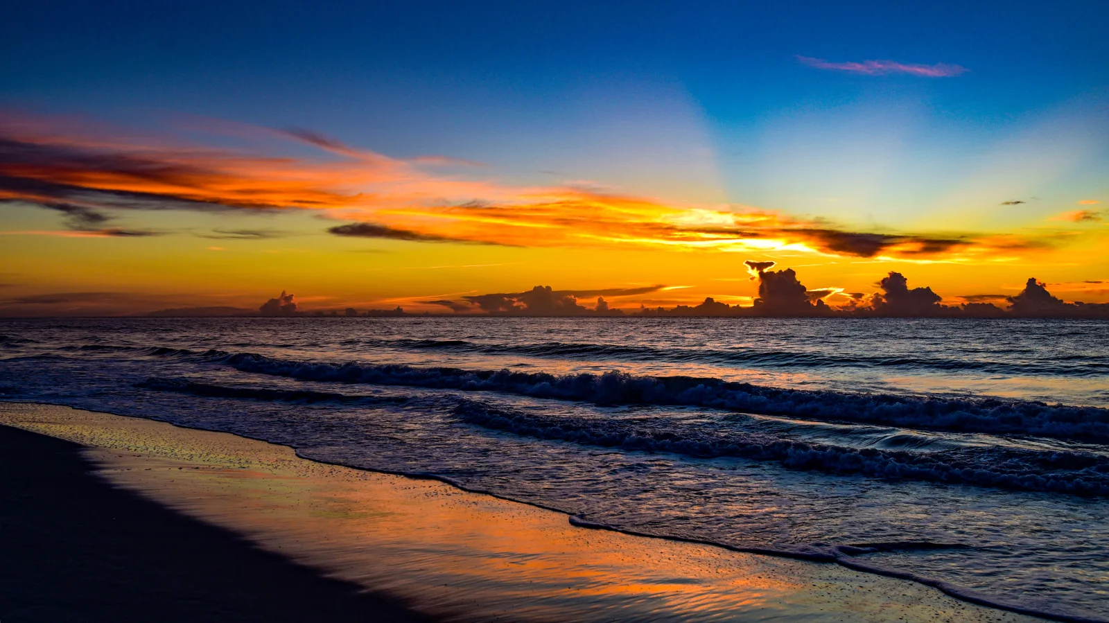 Leuchtende Strahlen Sonne bei Sonnenuntergang über dem Meer
