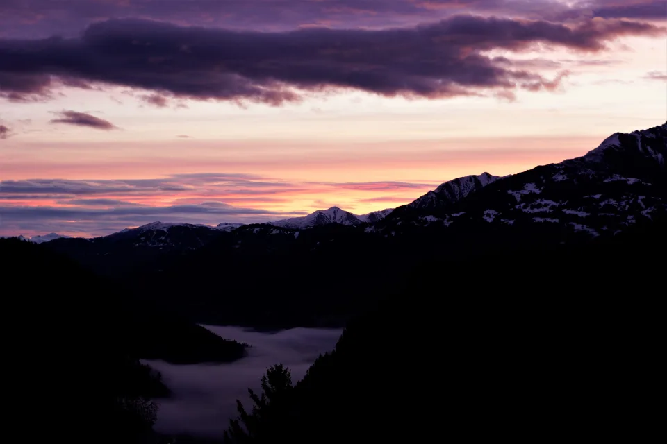 Rosa Sonnenuntergang über bedeckten Schnee Berge