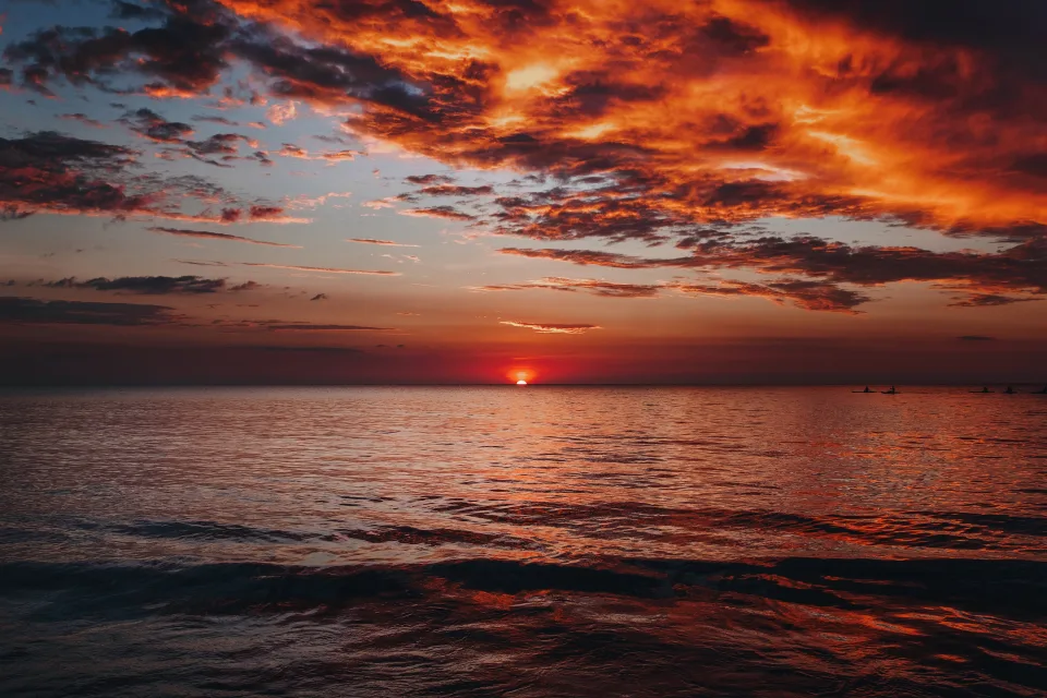 Rote Wolken in Himmel über dem Meer bei Sonnenuntergang