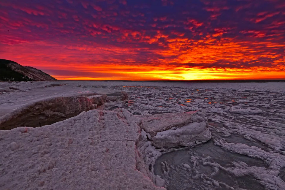 Roter Sonnenuntergang Sonne bedeckt vereistes See