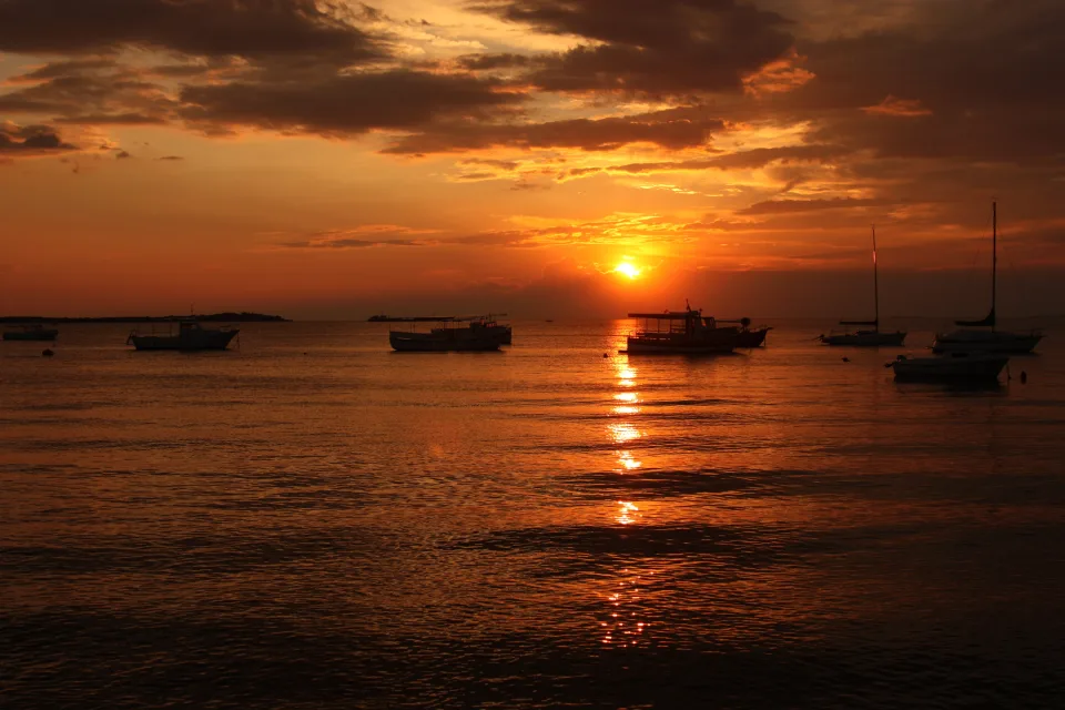 Schiffe bei Bootssteg im Meer bei Sonnenuntergang im Sommer