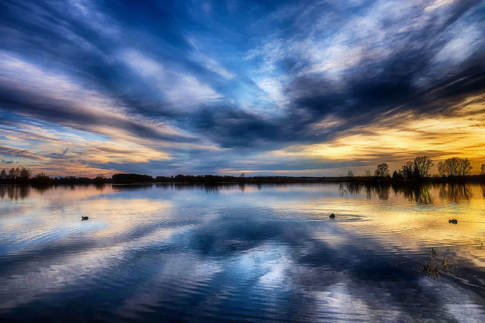 Schöner Himmel bei Sonnenuntergang spiegelt sich im See