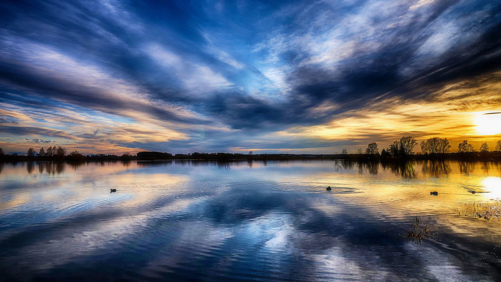 Schöner Himmel bei Sonnenuntergang spiegelt sich im See