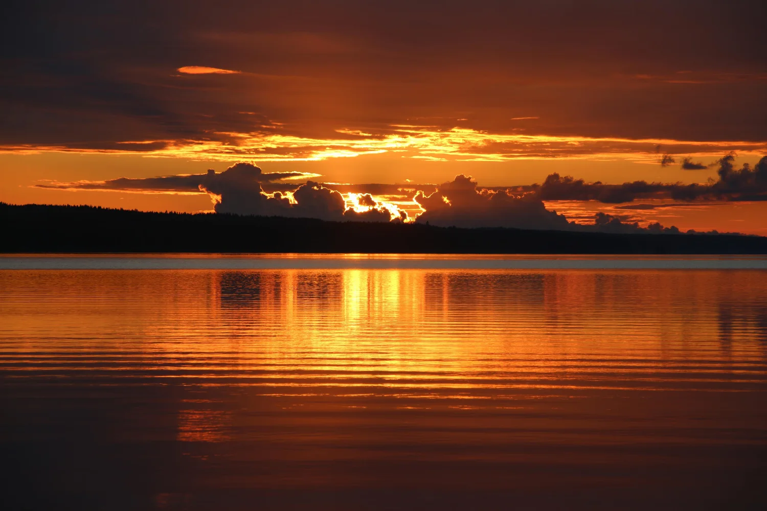 Schöner Sonnenuntergang in den Wolken auf Horizont am See