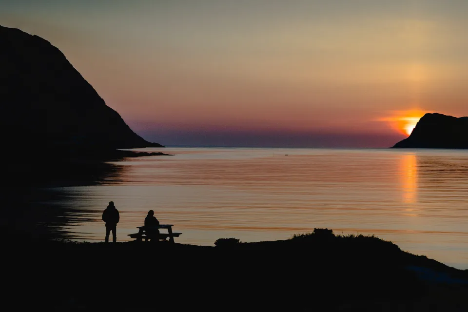 Sonne verschwindet hinter Berg in Bucht