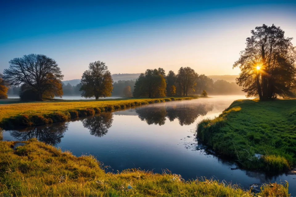 Sonne über Fluss im Nebel im Sommer