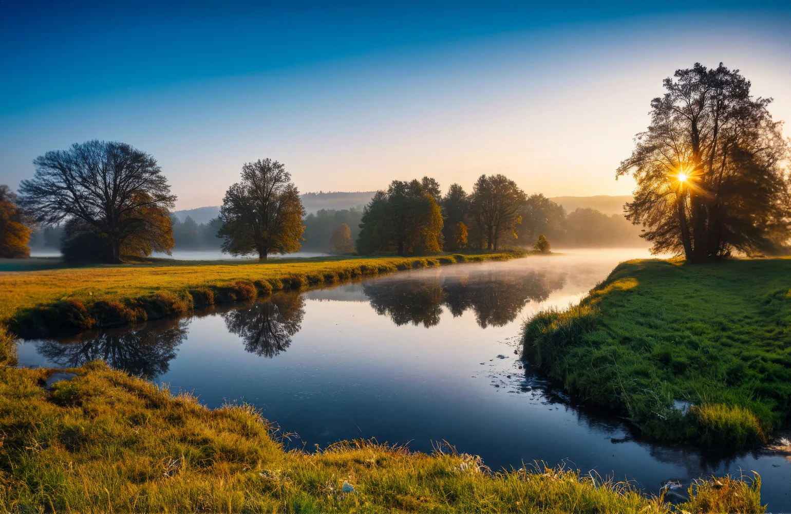 Sonne über Fluss im Nebel im Sommer